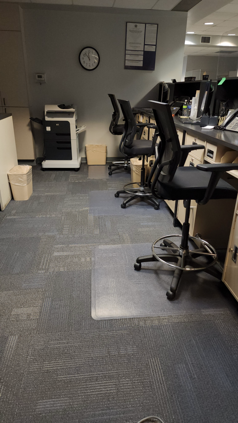 a row of office chairs that are in front of desks with a printer on the upper left hand corner.